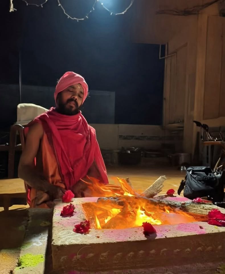 Swami Vishwananda seated in meditation before a sacred homa fire